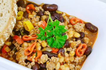 chili con carne on white bowl and Black bread or Rye bread