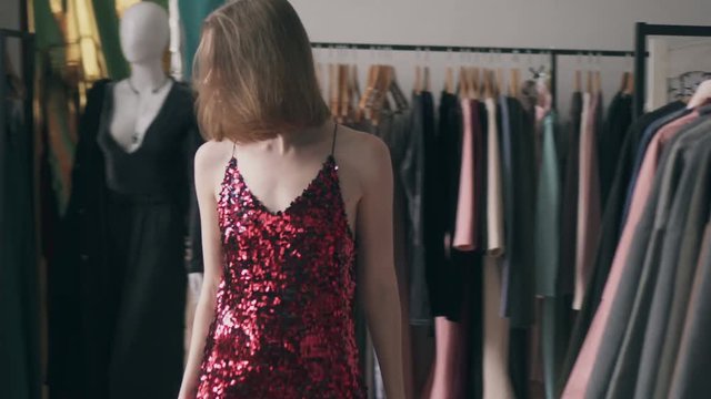 Young woman trying on red sequin dress
