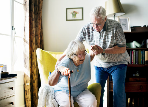 Senior man helping senior woman to stand