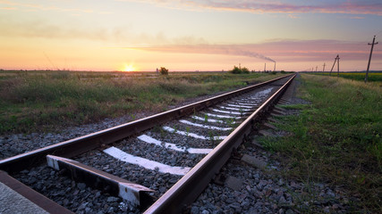 Fototapeta na wymiar Railway in the steppe / photo right after sunset road leading to the distance