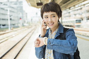 スマホを持った電車を待つ女性