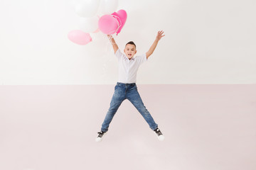Fototapeta na wymiar Cute little boy with balloons jumping. 