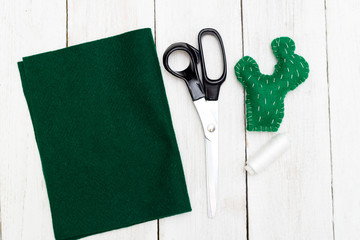 Green cactus from felt on a white wooden background. Toy handmade © _nastassia