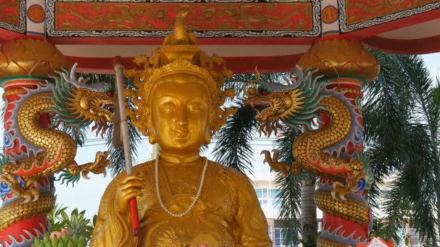 Golden statue of a Chinese god surrounded by columns of dragons. Chinese temple Ang Force in Pattaya.