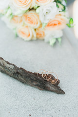 Wedding bouquet in pastel colors and wedding rings from gold