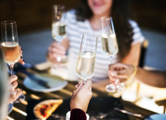 Girl friends toasting at dinner together at a rooftop bar