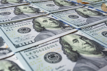 Hundred dollar bills close up as background with shallow depth of field
