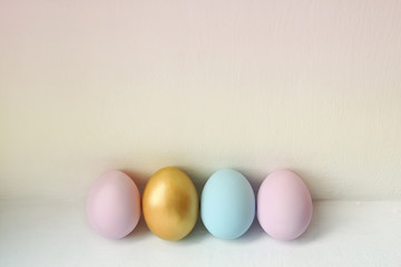 A row of pastel colored Easter eggs on white background. Festive easter background in minimalism style.