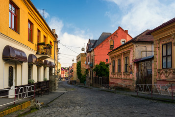 Fototapeta na wymiar empty street of old town on summer morning. cobblestone pavement on the ground. beautiful scenery with architecture of Austria-Hungary times.