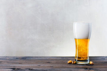 Glass of light beer on the wooden table