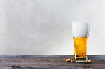 Photo sur Plexiglas Bière Verre de bière légère sur la table en bois