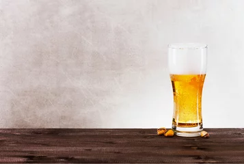 Gordijnen Glass of light beer on the wooden table © alinakho