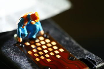 Miniature maintenance figure model in action of inspection old used ink cartridge contact sensor...