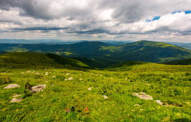 Naklejka premium boulders on the hillside. mountain summer landscape. meadow with huge stones among the grass on top of the hill