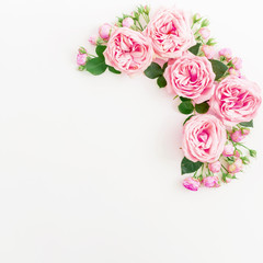 Frame made of pink roses, buds and petals on white background. Floral composition. Flat lay, Top view.