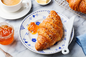 Croissant with coffee, jam and butter. Continental breakfast concept