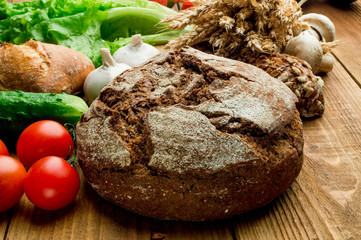 Set of vegetables and bread on a wooden board