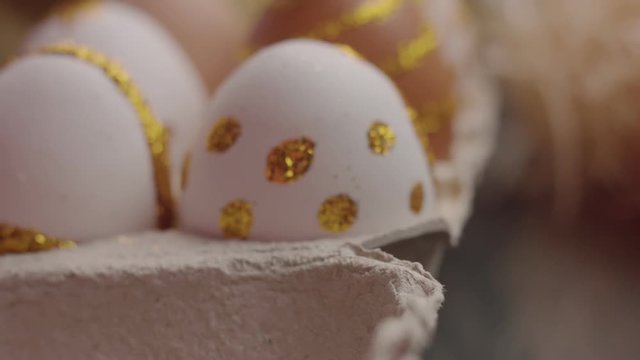 closeup of easter eggs painting in golden glitter camera moving slowly