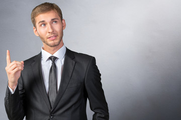 Young Businessman pointing up