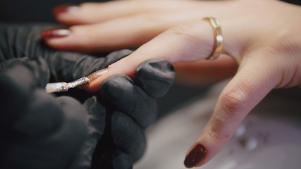 Obraz na płótnie Canvas Working manicurist - nail master in medical mask doing professional manicure