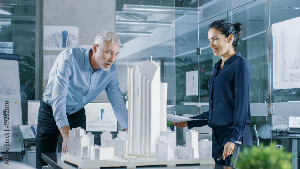 Aufkleber in the architectural bureau female engineer brings blueprints and shows them to senior architect, th