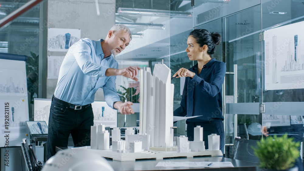 Aufkleber two professional male and female architectural engineers work with blueprints and on a building mode