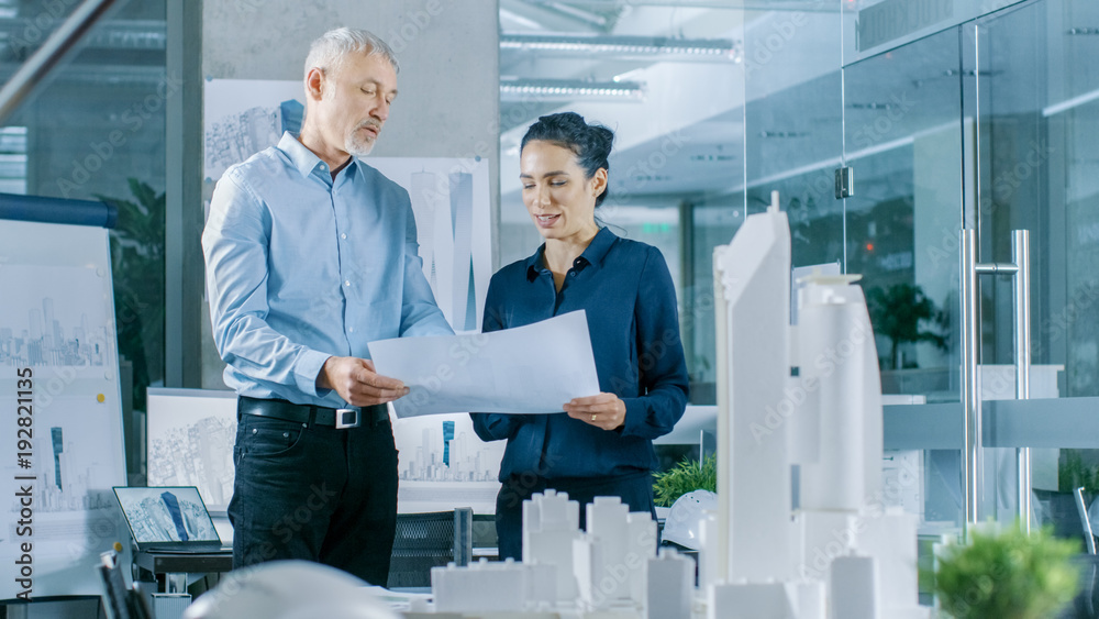 Aufkleber two professional male and female architectural engineers work with blueprints, discussing building m