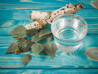 A glass of birch juice on wooden background