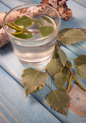 A glass of birch juice on wooden background