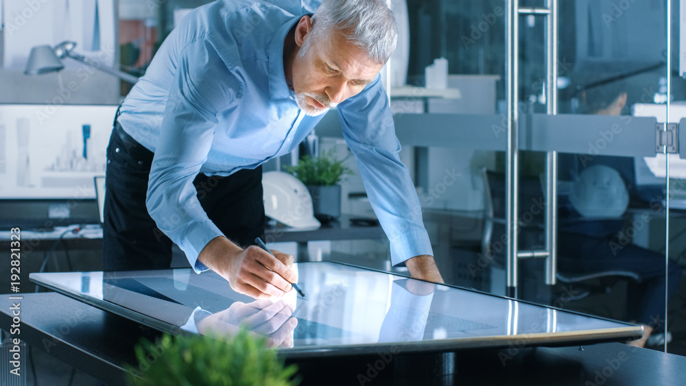 Aufkleber senior architectural engineer draws building concept on a graphics tablet display vertical touchscre