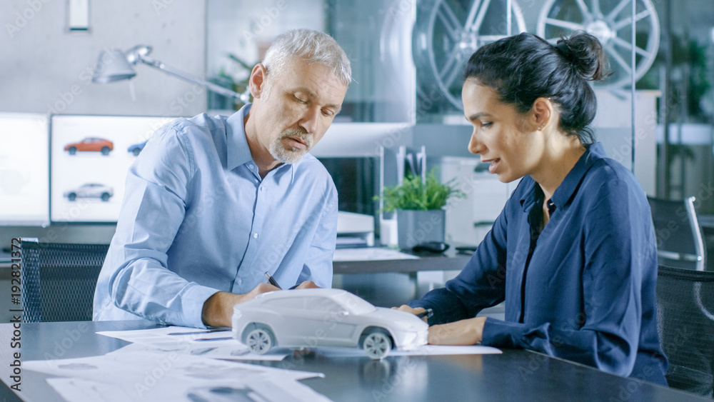 Aufkleber experienced automotive designer and female engineer works with blueprints and sketches of a new car 