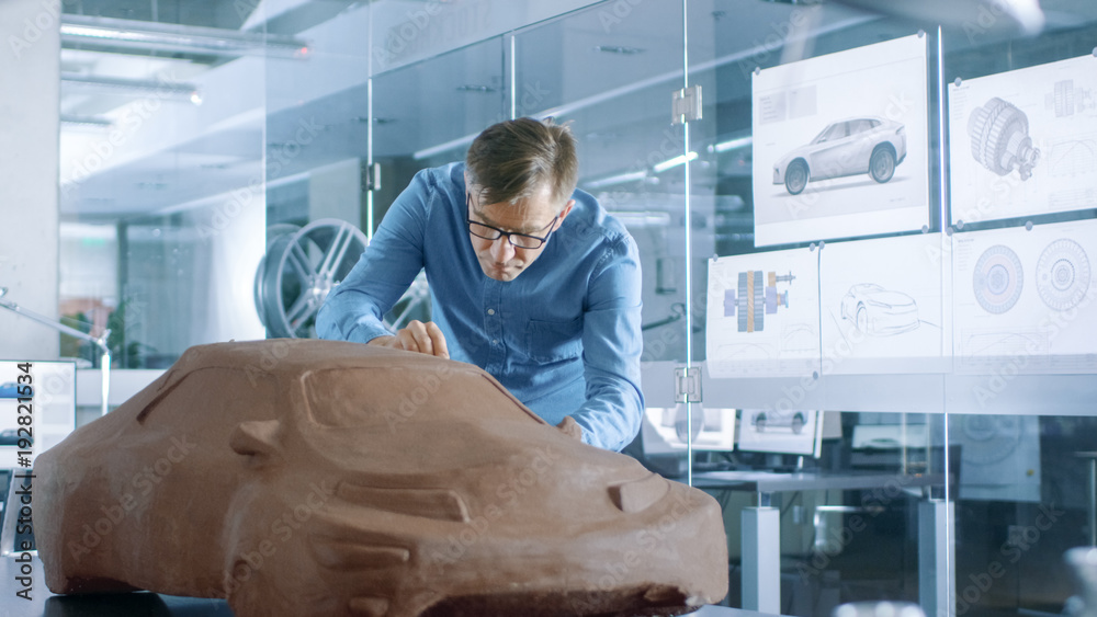 Poster experience automotive designer with a rake sculpts prototype car model from plasticine clay. he work