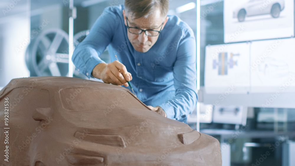 Poster experience automotive designer with a rake sculpts prototype car model from plasticine clay. he work