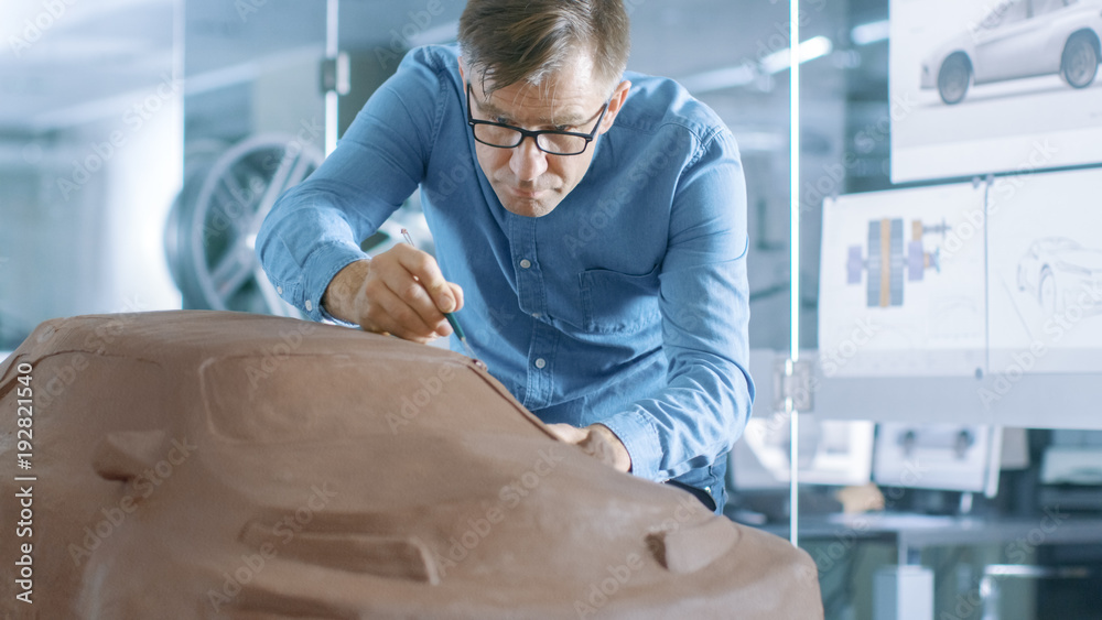 Poster experience automotive designer with a rake sculpts prototype car model from plasticine clay. he work