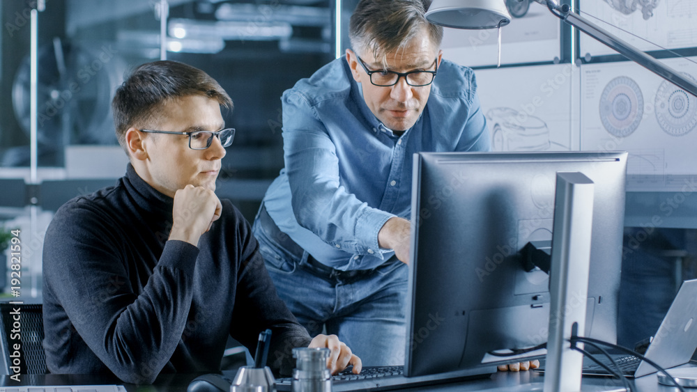 Aufkleber experienced senior engineer consults young designer about project, they have discussion and work on 