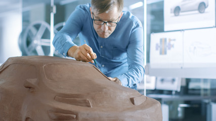 Experience Automotive Designer with a Rake Sculpts Prototype Car Model from Plasticine Clay. He...