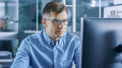 Chief Industrial Engineer Working on Personal Computer in the Stylish, Modern, Glass Office.