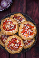Mini pizza, vegetable galette with cream cheese, red onion, tomatoes, sweet pepper and almonds