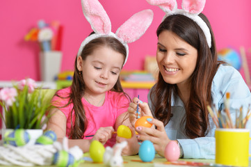 Obraz na płótnie Canvas girl with mother painting eggs