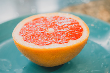 A half of a grapefruit closeup on grey background