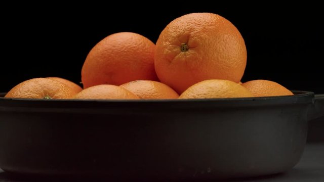 closeup of oranges on black background. Fresh with drops of water on peel. closeup of wet orange cut