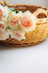 Obraz na płótnie Canvas Bouquet of pale pink cream roses in a woven basket on a windowsill. Soft focus. Romance background with copy space.