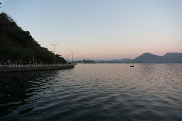 Serene dawn shot of Fateh sagar lake udiapur india. This famous tourist destination of India invites locals and travellers alike to enjoy the blue waters, surrounding hills and great lakeside food