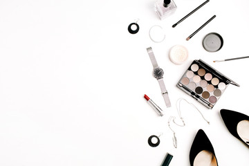 Female fashion accessories and cosmetics. Hat, shoes, palette, lipstick, watches, powder on white background. Flat lay, top view.