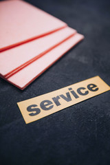 Cleaning house or office concept. Pink cleaning rag, Service inscription on a dark concrete background. Top view, closeup