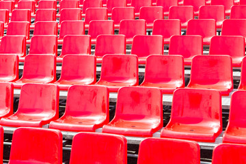 Naklejka premium Rows empty bright red plastic seats in a stadium