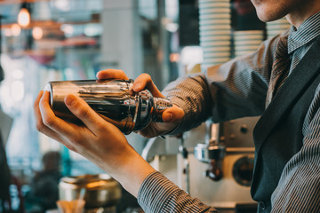 Barman In Pub Holding Shaker. Focus Is On Shaker.