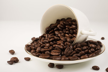White cup with coffee beans on white background