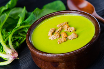 Spinach soup served on wooden board 