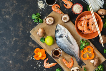 Products for cooking. Asian cuisine and Mediterranean cuisine. Fish, shrimp, mushrooms. Top view, copy space.